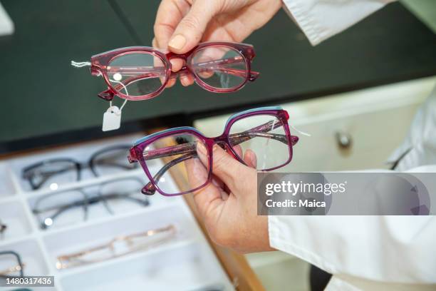 mains d’optométriste tenant des lunettes - lunettes de vue photos et images de collection