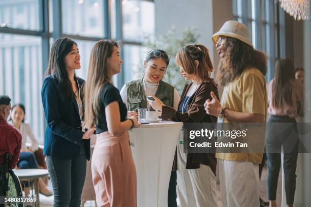 jeunes professionnels asiatiques ayant une conversation informelle après un événement de conférence réussi - afterwork photos et images de collection