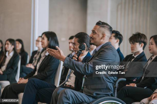 empresário indiano em cadeira de rodas fazendo pergunta em seminário de conferência de negócios - summit meeting - fotografias e filmes do acervo