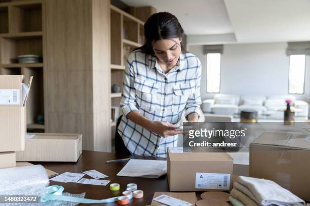 female entrepreneur shipping orders while running her business from home - sending bildbanksfoton och bilder