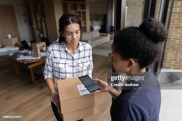 businesswoman shipping some packages using a delivery person - global entry stock pictures, royalty-free photos & images