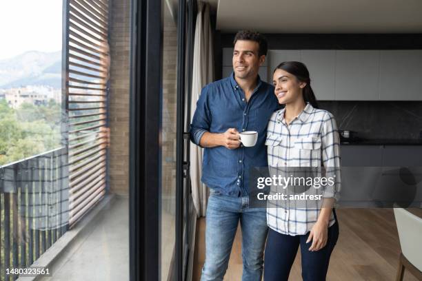 loving couple relaxing at home drinking a cup of coffee - two people looking at view stock pictures, royalty-free photos & images