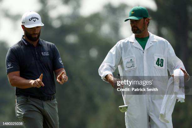 Jon Rahm of Spain reacts to his putt with caddie Adam Hayes on the third green during the first round of the 2023 Masters Tournament at Augusta...