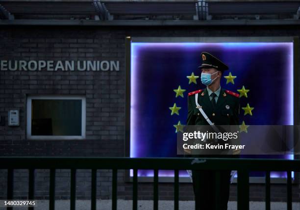 Member of the Peoples Armed Police stands guard in frpnt of the flag of the European Union at the European Delegation before a press conference by...