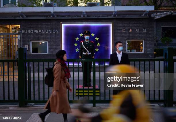 Members of the Peoples Armed Police stand guard in front of the flag of the European Union at the European Delegation before a press conference by...