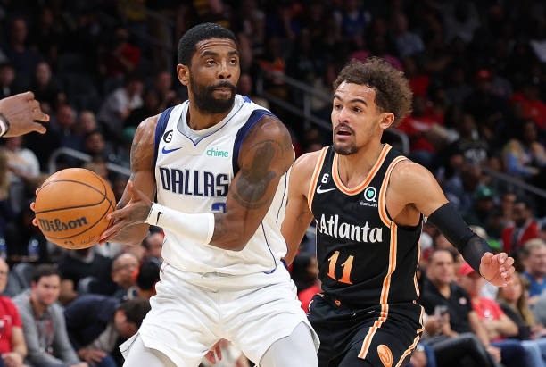 Kyrie Irving of the Dallas Mavericks drives against Trae Young of the Atlanta Hawks during the second quarter at State Farm Arena on April 02, 2023...