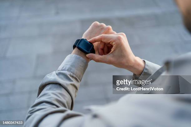man checking his smartwatch - cronógrafo imagens e fotografias de stock