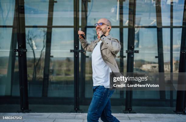 young happy man listening to music on earphones - dancing outside stock pictures, royalty-free photos & images