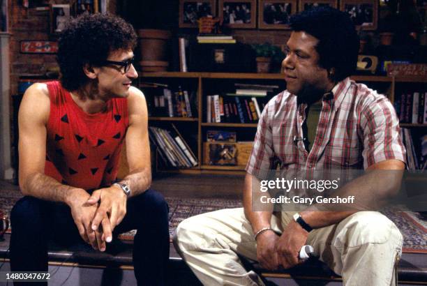 View of American Rock musician Donnie Iris , of the band Donnie Iris and the Cruisers, and MTV VJ JJ Jackson as they sit on a low stage during an...