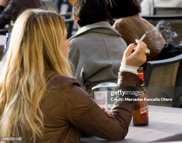 rear view of blonde young woman smoking. - café esplanada imagens e fotografias de stock