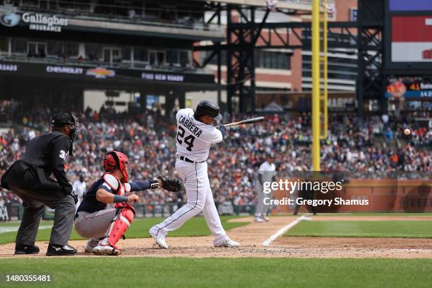 Miguel Cabrera of the Detroit Tigers hits a fourth inning RBI single in front of Reese McGuire of the Boston Red Sox during opening day at Comerica...