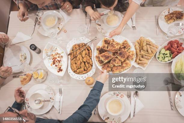 vista de alto ángulo de una familia islámica cenando juntos en casa - arab family eating fotografías e imágenes de stock