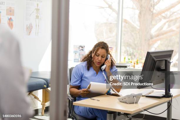 female nurse makes patient calls as unrecognizable doctor arrives - doctor using phone stock pictures, royalty-free photos & images