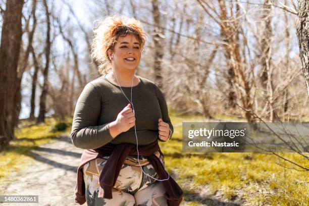 woman with curly hair running - athlete torso stock pictures, royalty-free photos & images