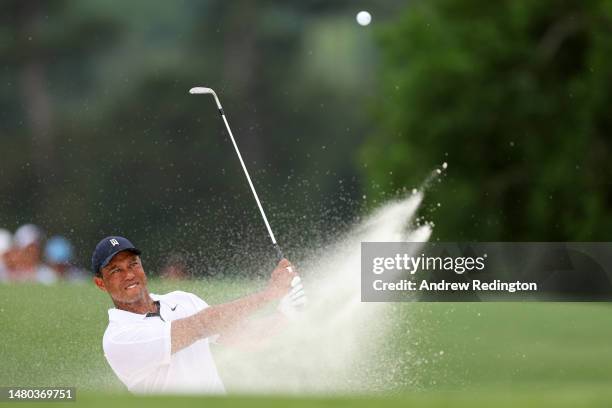 Tiger Woods of the United States plays a shot from a bunker on the 18th hole during the first round of the 2023 Masters Tournament at Augusta...