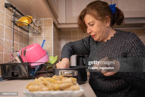 the türkish woman is putting the cabbage roll on the plates for serving . - turkish food stock pictures, royalty-free photos & images