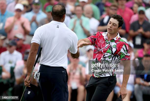 Viktor Hovland of Norway and Tiger Woods of the United States shake hands on the 18th green during the first round of the 2023 Masters Tournament at...