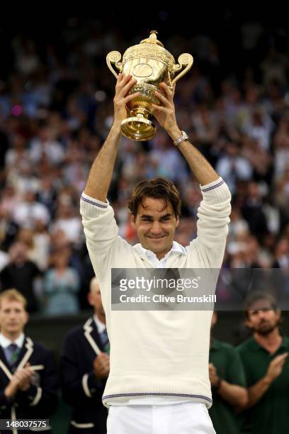 Roger Federer of Switzerland holds up the winner's trophy after winning his Gentlemen's Singles final match against Andy Murray of Great Britain on...