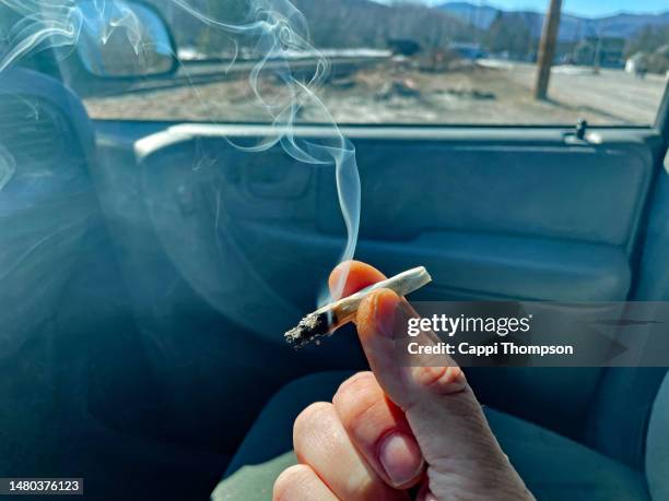 smoking marijuana in a car - stoned stock-fotos und bilder