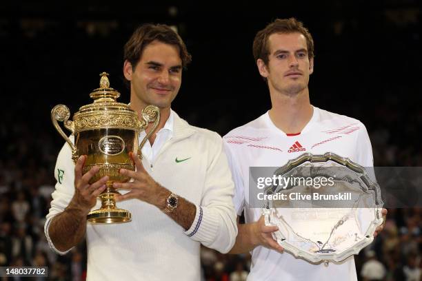 Winner Roger Federer of Switzerland and runner up Andy Murray of Great Britain hold up their trophies after their Gentlemen's Singles final match on...