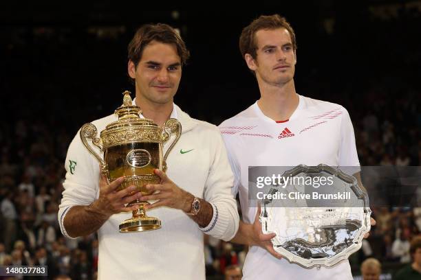 Winner Roger Federer of Switzerland and runner up Andy Murray of Great Britain hold up their trophies after their Gentlemen's Singles final match on...