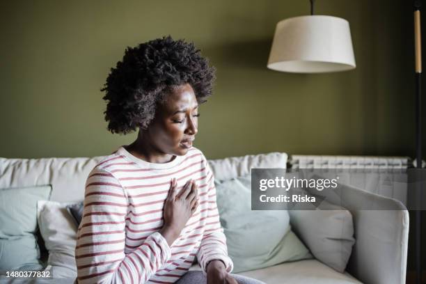 a young woman is having chest pains - woman's chest stock pictures, royalty-free photos & images