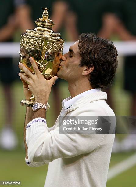 Roger Federer of Switzerland kisses the winner's trophy after winning his Gentlemen's Singles final match against Andy Murray of Great Britain on day...