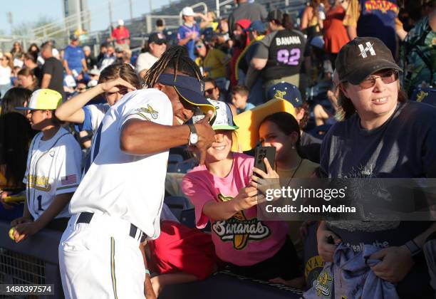 Savannah Bananas first base coach Maceo Harrison takes a selfie with a fan before the Savannah Bananas entertain a record-breaking crowd at Peoria...