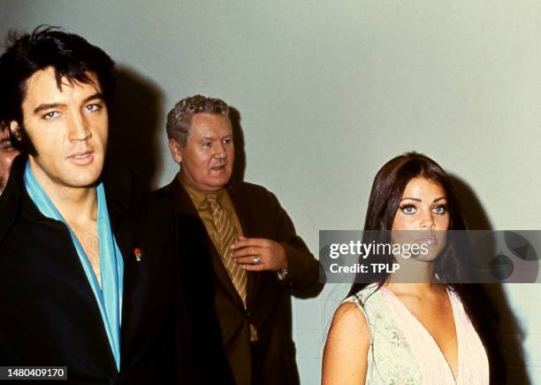 American singer Elvis Presley walks with his wife, actress Priscilla Presley and father Vernon Presley circa 1970.