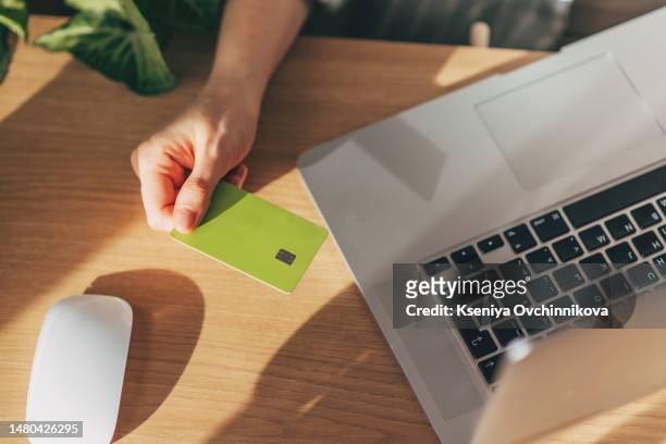 hands holding plastic credit card and using laptop. online shopping concept. toned picture - keypad stock pictures, royalty-free photos & images