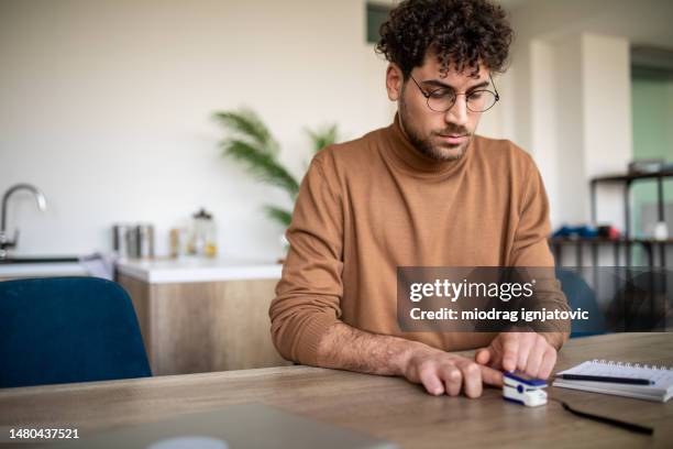 man using digital pulse oximeter - pulse oximeter stock pictures, royalty-free photos & images