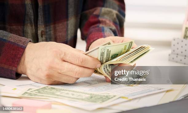 close up of man's hand holding and counting money, dollars banknotes, - us federal trade commission stock pictures, royalty-free photos & images