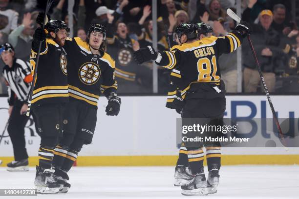 David Pastrnak of the Boston Bruins celebrates with Tyler Bertuzzi and Dmitry Orlov after scoring the game winning goal against the Toronto Maple...