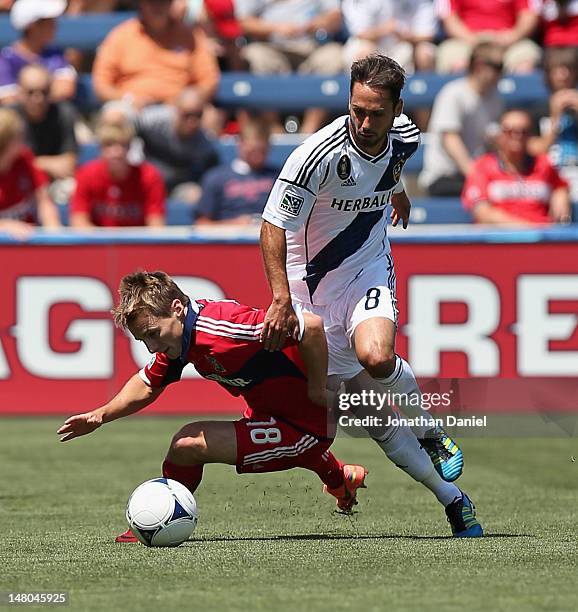 Marcelo Sarvas of the Los Angeles Galaxy knocks down Chris Rolfe of the Chicago Fire during an MLS match at Toyota Park on July 8, 2012 in...