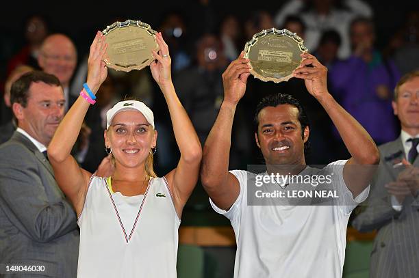 India's Leander Paes and Russia's Elena Vesnina hold up their runners-up trophies after their mixed doubles final defeat to US player Mike Bryan and...