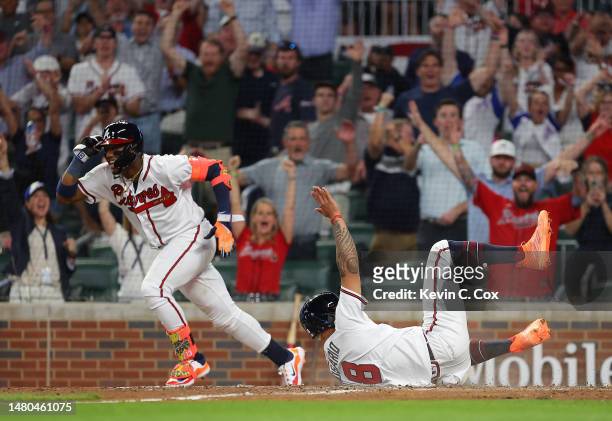 Eddie Rosario of the Atlanta Braves scores the game-winning run on a walk-off single hit by Orlando Arcia in the ninth inning against the San Diego...