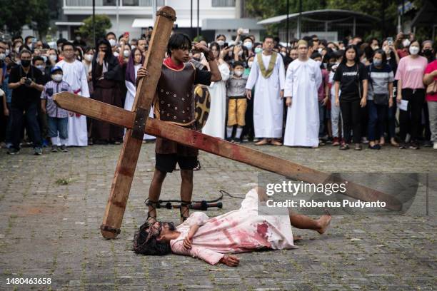 Indonesian Catholic devotees participate in a re-enactment of the crucifixion of Jesus Christ during a Good Friday procession at Roh Kudus Church on...