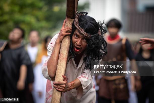 Indonesian Catholic devotees participate in a re-enactment of the crucifixion of Jesus Christ during a Good Friday procession at Roh Kudus Church on...