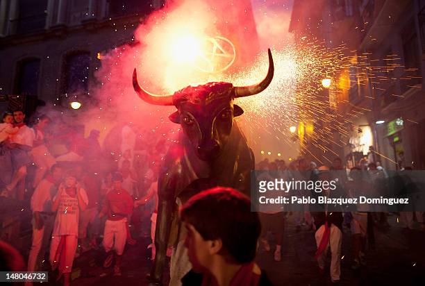 Toro del Fuego, flaming bull, is run through the streets of Pamplona on the second day of the San Fermin running of the bulls on July 8, 2012 in...