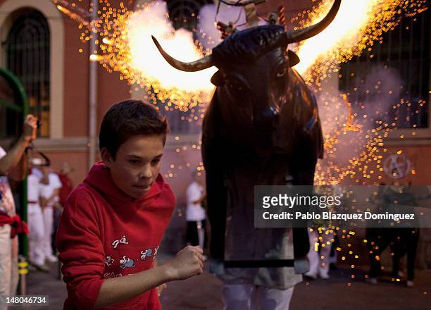 Toro del Fuego, flaming bull, is run through the streets of Pamplona on the second day of the San Fermin running of the bulls on July 8, 2012 in...
