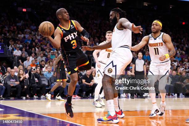 Chris Paul of the Phoenix Suns passes around DeAndre Jordan of the Denver Nuggets during the second half at Footprint Center on April 06, 2023 in...