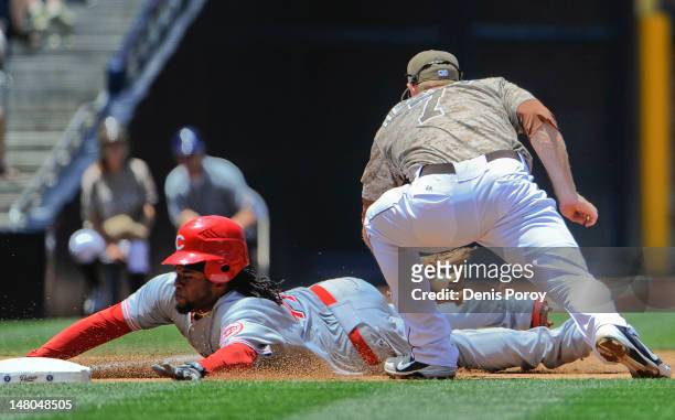 Johnny Cueto of the Cincinnati Reds slides safely into third base ahead of the tag of Chase Headley of the San Diego Padres during the third inning...