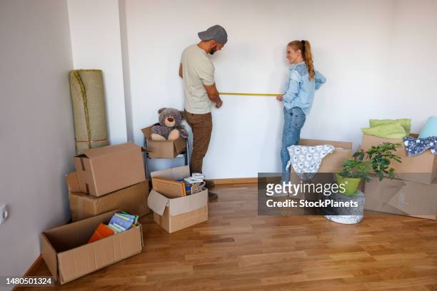 couple using tape measure in their new apartment - woman measuring tape stock pictures, royalty-free photos & images