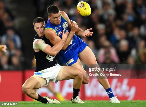 Luke Davies-Uniacke of the Kangaroos handballs whilst being tackled during the round four AFL match between North Melbourne Kangaroos and Carlton...