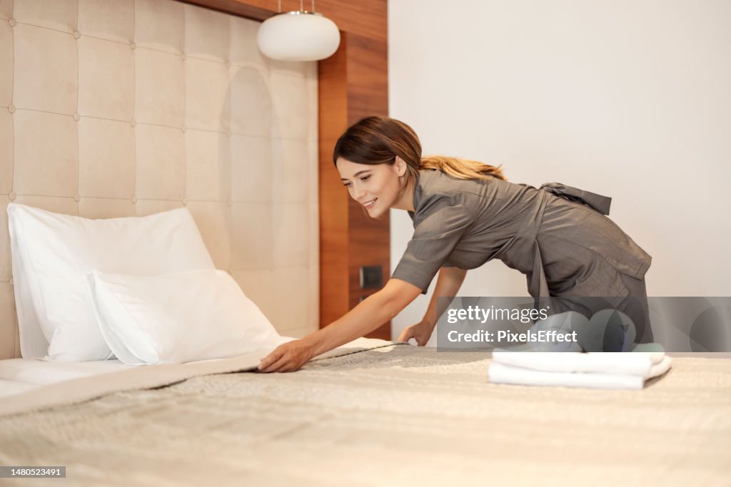 Maid Making Bed at the Hotel Room
