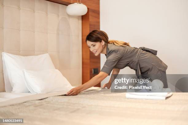 maid making bed at the hotel room - criada imagens e fotografias de stock