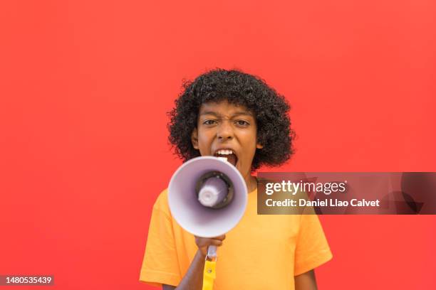 a 11 year old  boy yells energetically into a megaphone - fondo rojo stock pictures, royalty-free photos & images