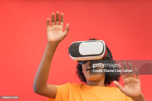 boy with virtual reality headset against red background - fondo rojo stock pictures, royalty-free photos & images