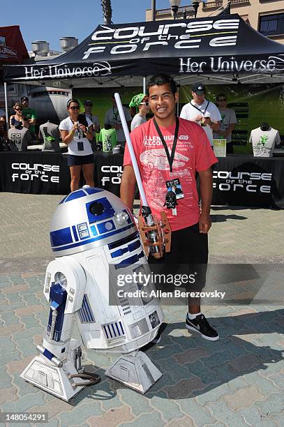 Leg winner Vincent Ramirez poses with R2D2 at the "Course Of The Force" - Inaugural "Star Wars" Relay "Conival" at Southside Huntington Beach Pier on...