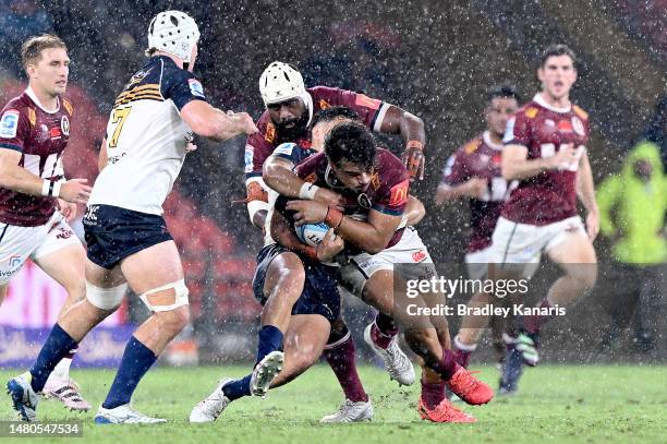 Jordan Petaia of the Reds is tackled during the round seven Super Rugby Pacific match between Queensland Reds and ACT Brumbies at Suncorp Stadium, on...